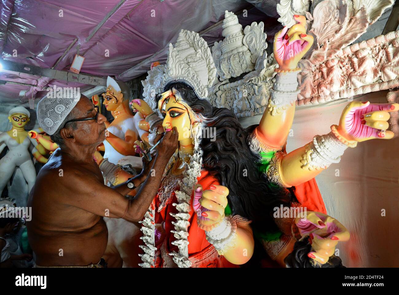 Ein achtogenarieller Künstler malt ein Idol der Hindu-Göttin Durga in Vorbereitung auf das bevorstehende hinduistische religiöse Festival Durga Puja in Kolkata. Stockfoto