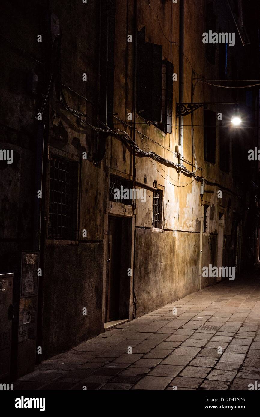 Leere Straße in der Nacht in venedig durch Straßenbeleuchtung erleuchtet Stockfoto