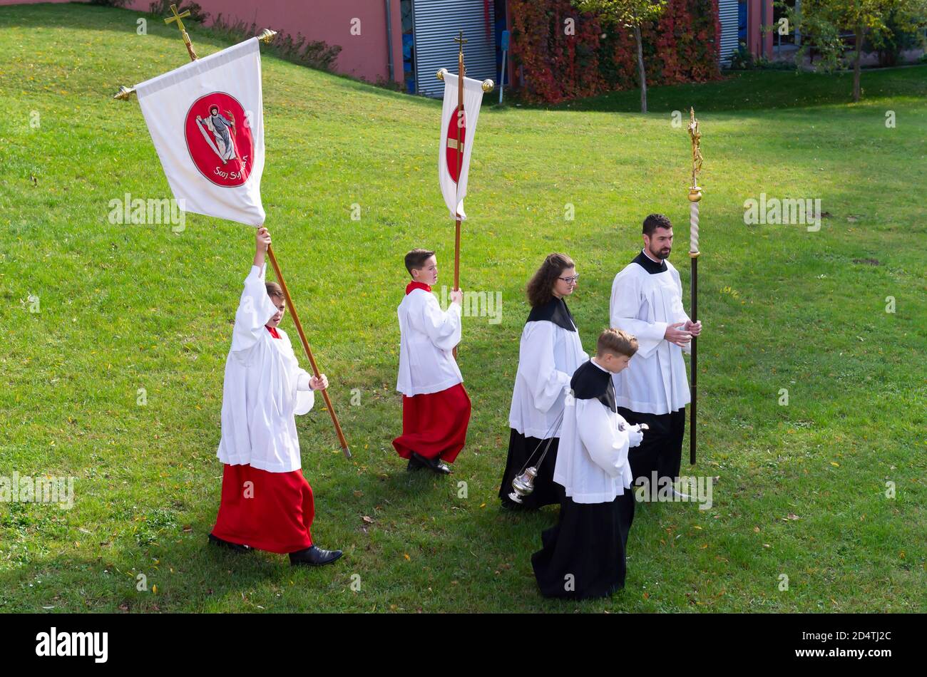 Crostwitz, Deutschland. Oktober 2020. Priester und Altarjungen gehen nach einem Konfirmationsgottesdienst um das Kirchgelände. In der Kirche Crostwitz erhalten etwa 40 Jugendliche ihre Konfirmation. Einige Frauen tragen traditionell das sorbische Kostüm. In der katholischen Kirche ist die Firmung eines der Sakramente nach der Taufe und der ersten Kommunion. Quelle: Matthias Rietschel/dpa-Zentralbild/ZB/dpa/Alamy Live News Stockfoto