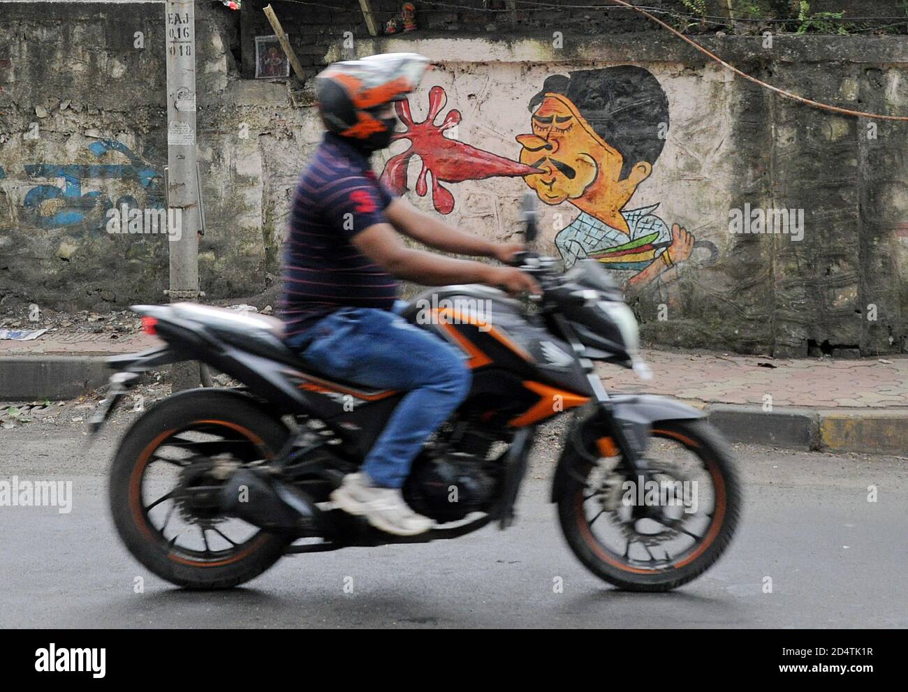 Mumbai, Indien. Oktober 2020. Ein Mann auf einem Motorrad fährt in Mumbai an einem Graffiti vorbei.Municipal Corporation schafft durch Graffiti Bewusstsein für die Gefahren des Spuckens in öffentlichen Plätzen. Die Bürger sind sich dieser Anweisung durch das Gesundheitsministerium bewusst und empfänglicher geworden, insbesondere jetzt aufgrund des Ausbruchs der Coronavirus-Pandemie. Kredit: SOPA Images Limited/Alamy Live Nachrichten Stockfoto
