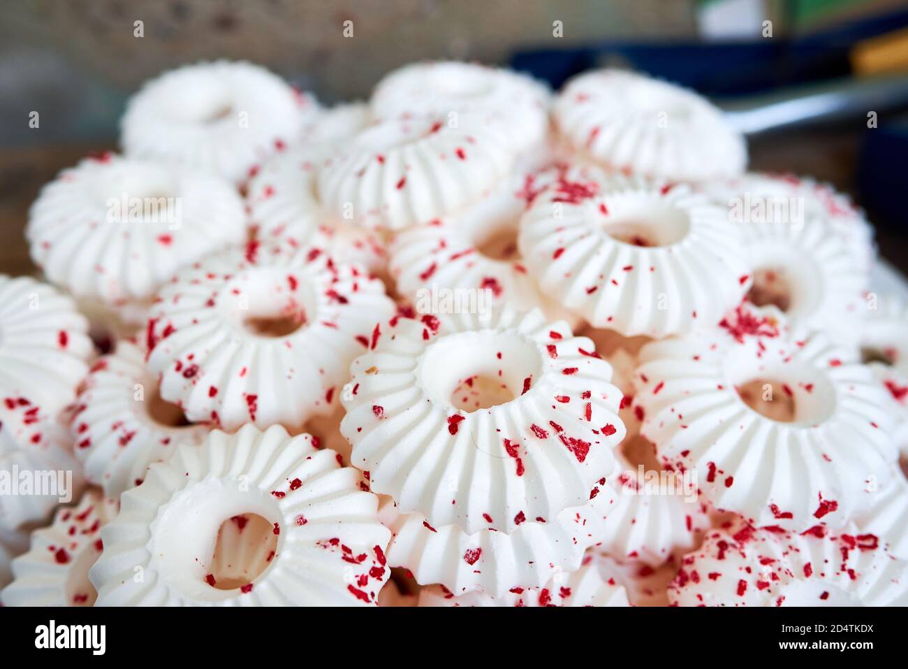 Hintergrund von weißen Baiser Kuchen mit roten Gebäck Krümel bestreut Stockfoto