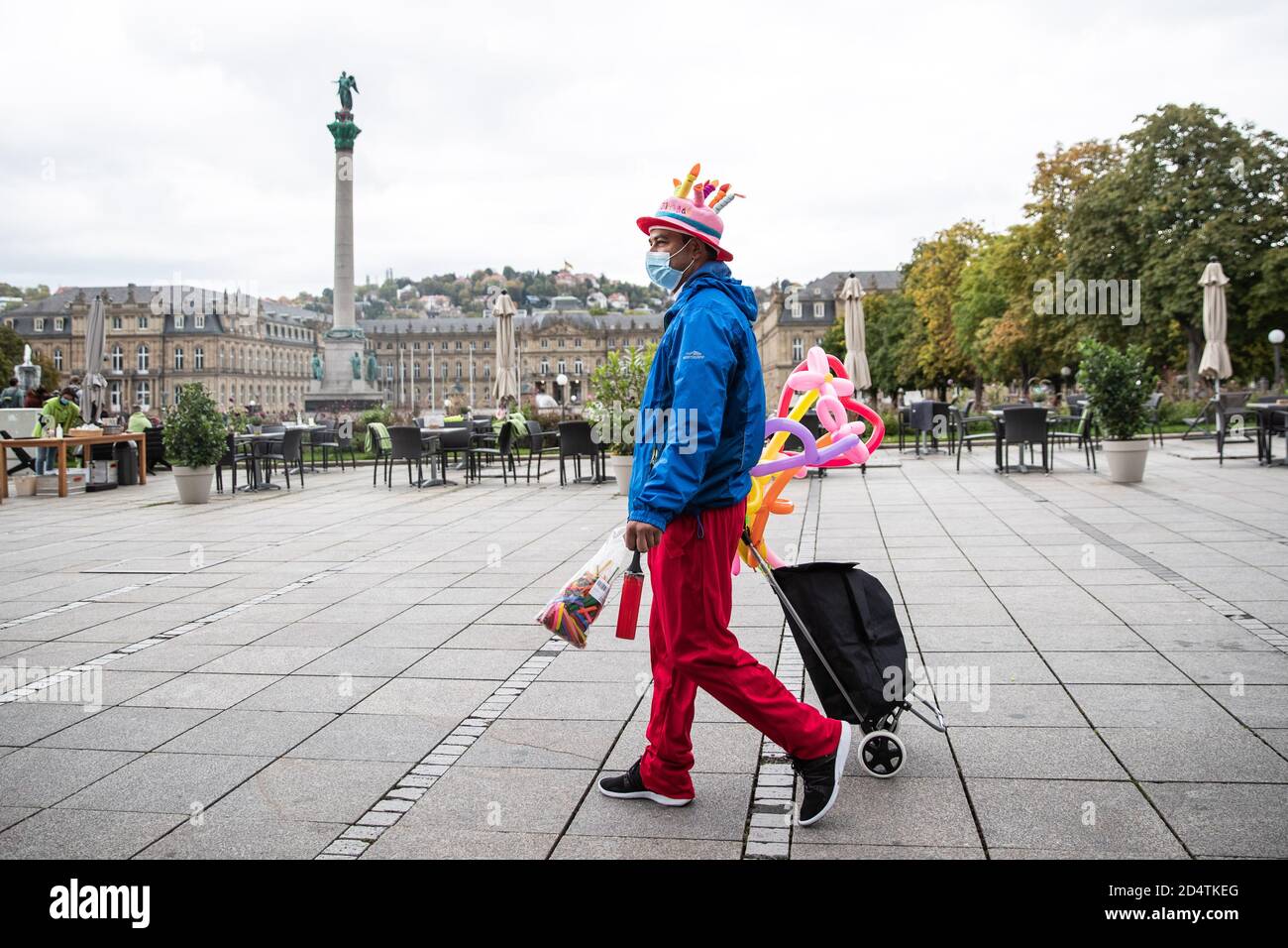 Stuttgart, Deutschland. Oktober 2020. Ein Ballonkünstler geht mit Mund und Nase über den leeren Schlossplatz. Nachdem in Stuttgart die Warngrenze von 50 Neuinfektionen pro 100,000 Einwohner in sieben Tagen überschritten wurde, diskutiert die Stadt die Ausgestaltung der angekündigten Maßnahmen. Quelle: Tom Weller/dpa/Alamy Live News Stockfoto