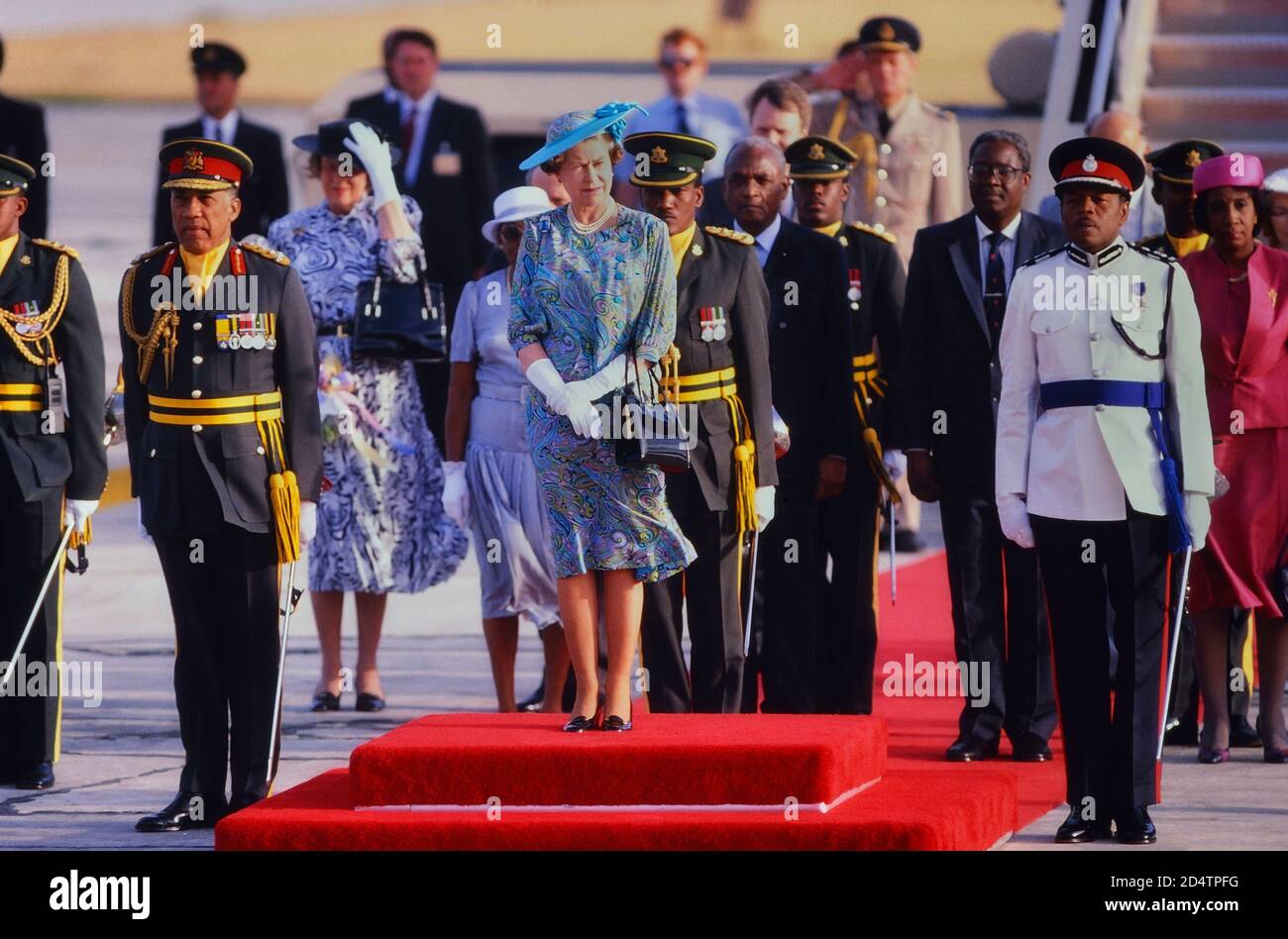 Königin Elizabeth II. Stand auf dem roten Teppich mit einer einladenden Party von Würdenträgern nach ihrer Ankunft am Grantley Adams International Airport, Barbados für eine Royal Tour 8-11. März 1989 Stockfoto