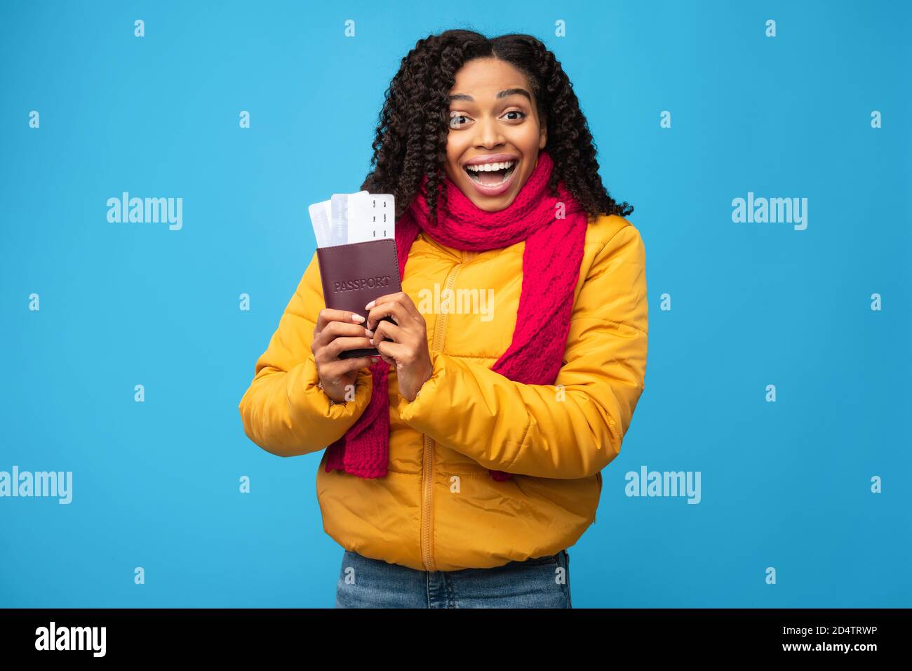 African Woman Holding Tickets Reisen Im Winterurlaub, Blauer Hintergrund Stockfoto