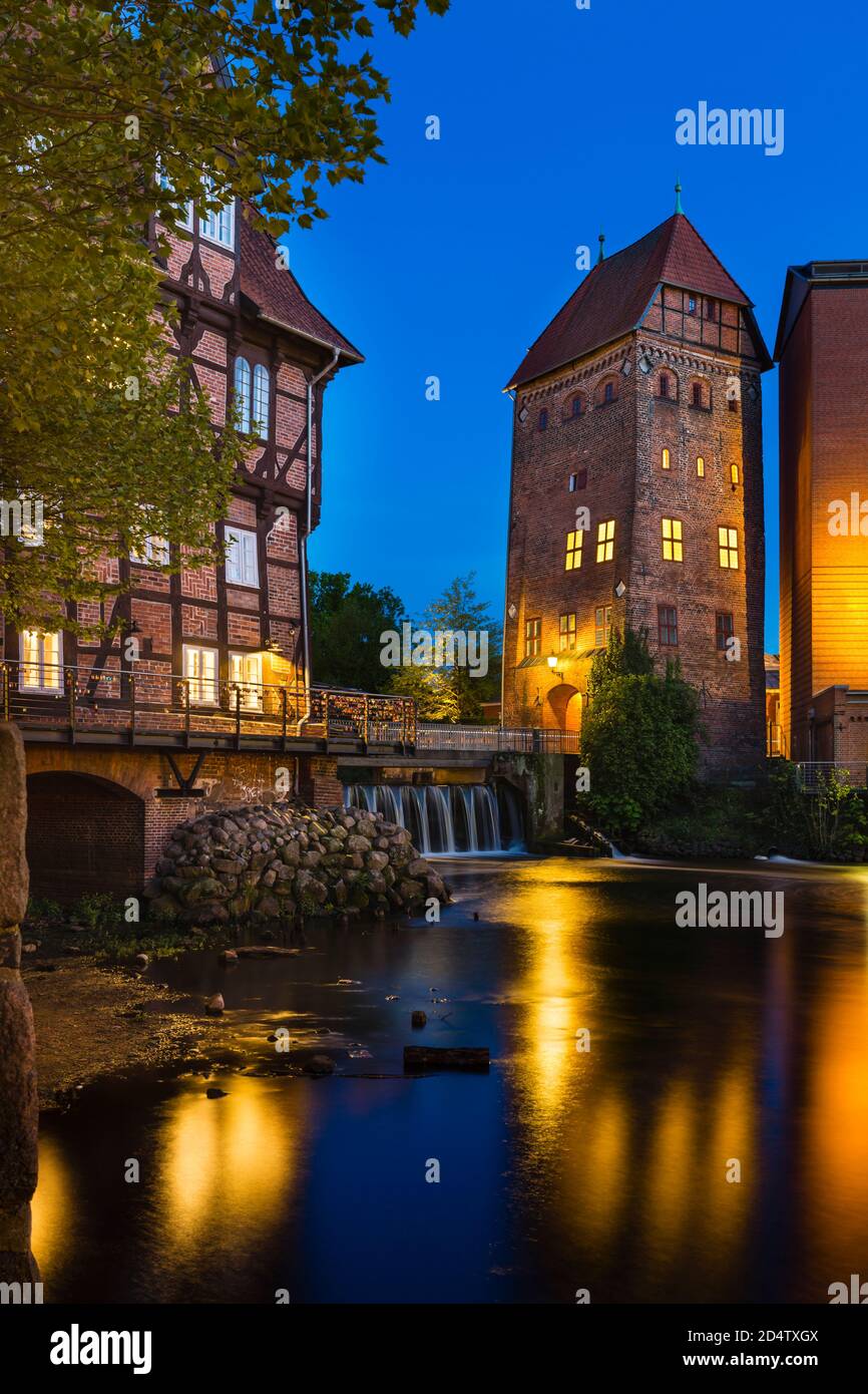 Alte Mühle und Turm an der Ilmenau in der Lüneburger Altstadt mit nächtblauem Himmel. Stockfoto