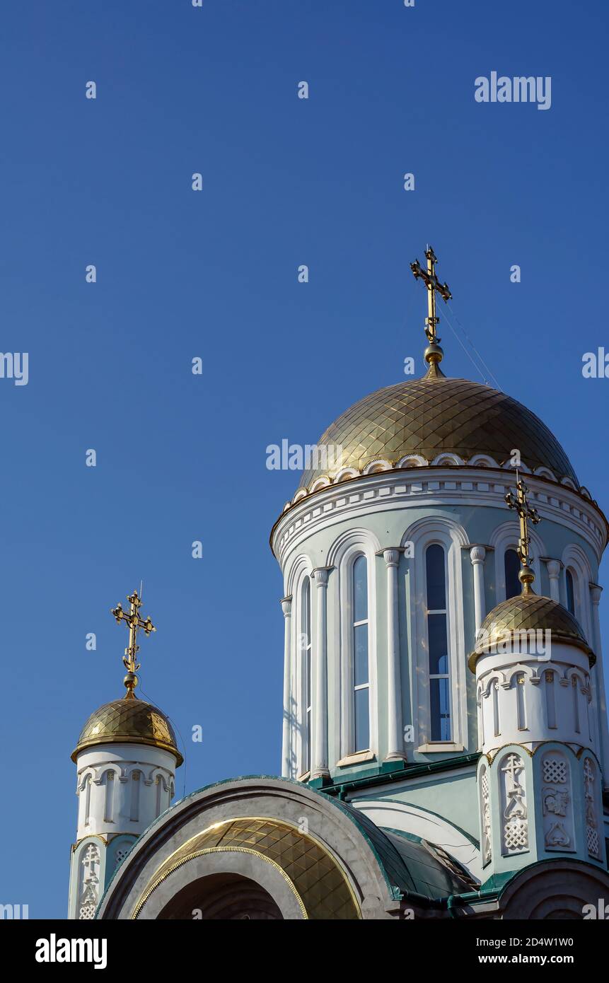 Neubau der ukrainischen christlich-orthodoxen Kirche gegen den Himmel. Vergoldete Kuppeln mit Kreuzen. Religiöse Themen. Ohne jemanden. Stockfoto