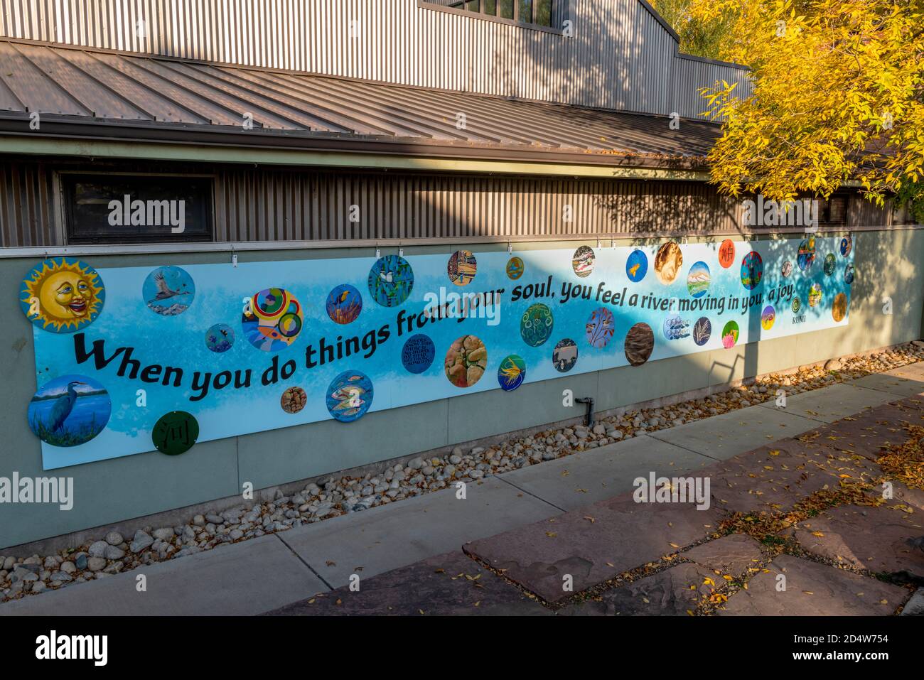 Farbenfrohe Wandgemälde mit Werken lokaler Künstler an der Seite des SteamPlant-Nebengebäudes in der historischen Innenstadt; kleine Bergstadt Stockfoto
