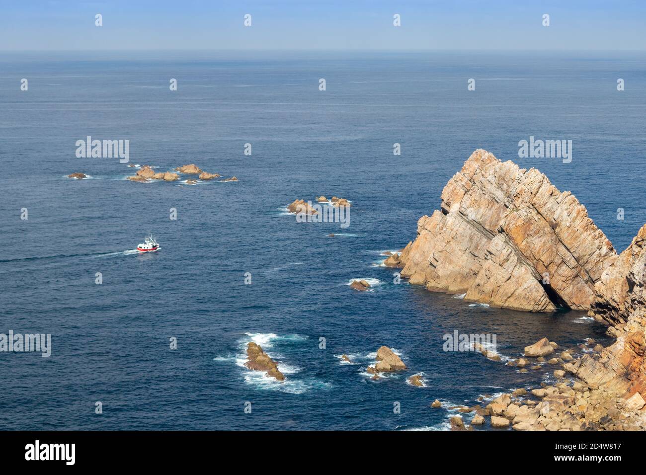 Rot-weiß traditionelles Fischerboot am Kap Peñas (Cabo de Peñas), dem nördlichsten Punkt der iberischen Halbinsel. Felsige Umhang und Böschungen durch die Stockfoto