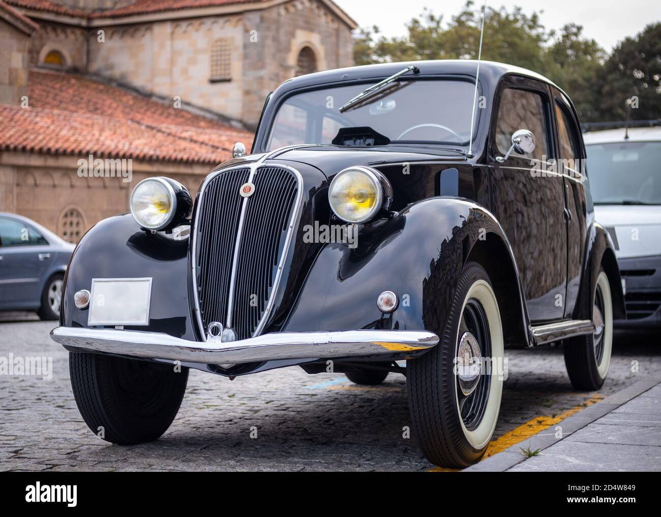 Spanien; Sep 2020: Italienischer Klassiker Fiat 500 Topolino. Ikonisches schwarzes Oldtimer auf der Straße geparkt. Gelbe Rundlichter, weiße Räder, Chromspiegel A Stockfoto