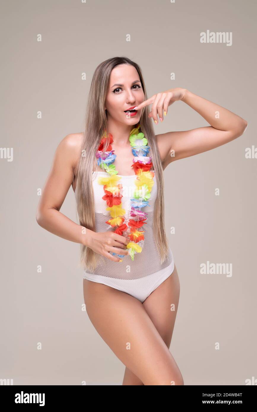 Schöne schlanke und fit Mädchen mit langen blonden Haaren in weißen Anzug. Leuchtende Haut Stockfoto