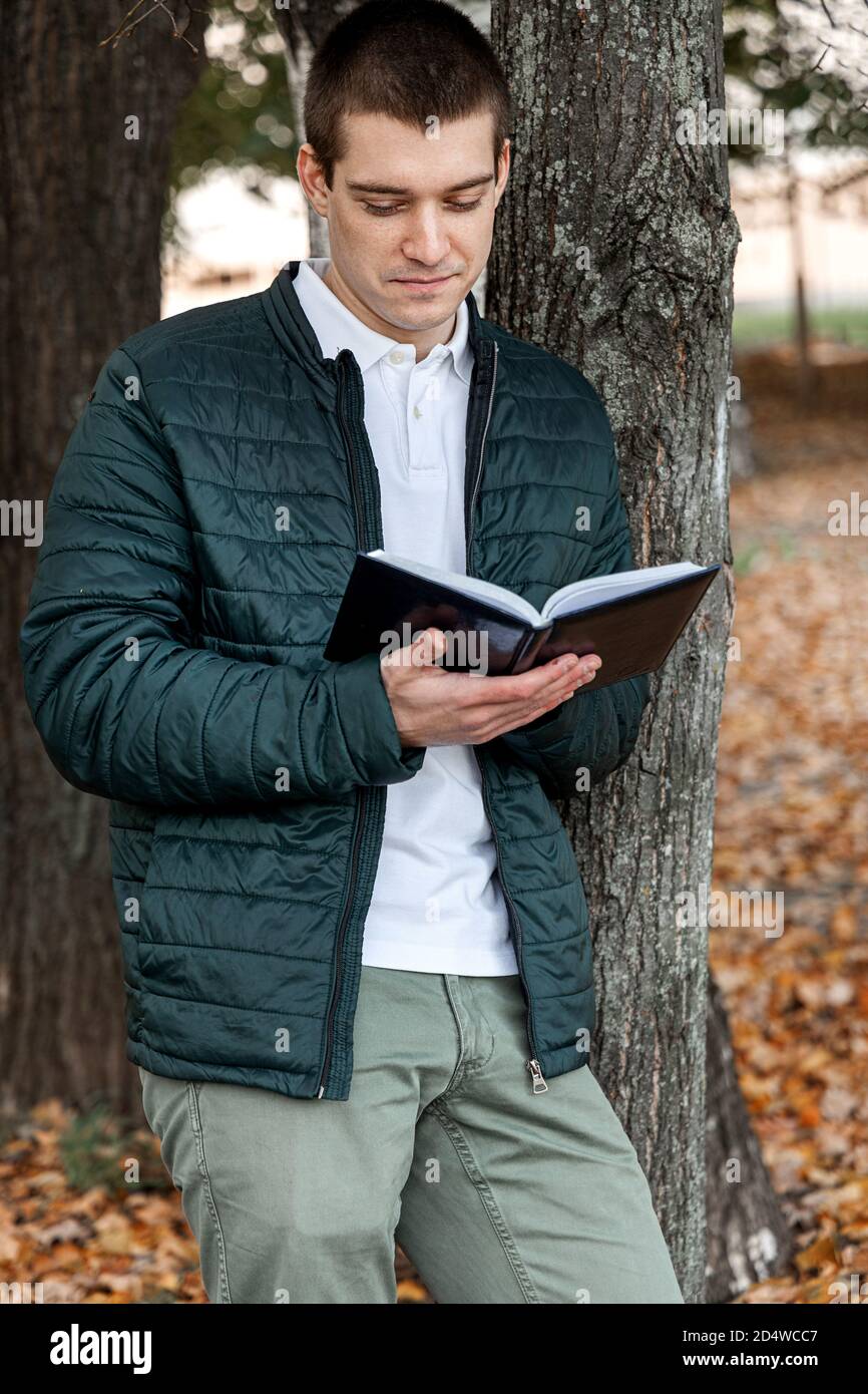 Mann liest ein Buch im Stadtpark im Freien Stockfoto