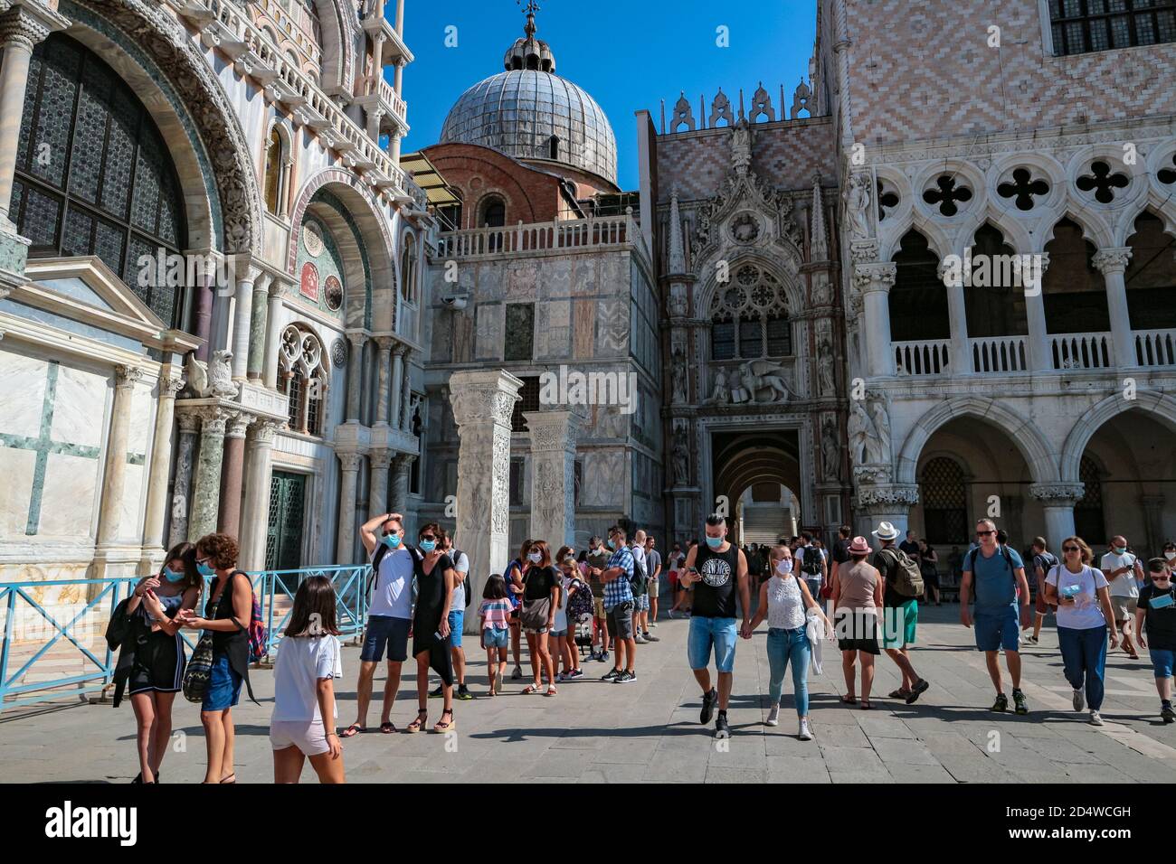 Neue normale Tourismus am Piazza San Marco (St. Markusplatz), Venedig, Italien, während der Coronavirus-Pandemie mit Touristen, die Gesichtsmasken tragen. Stockfoto