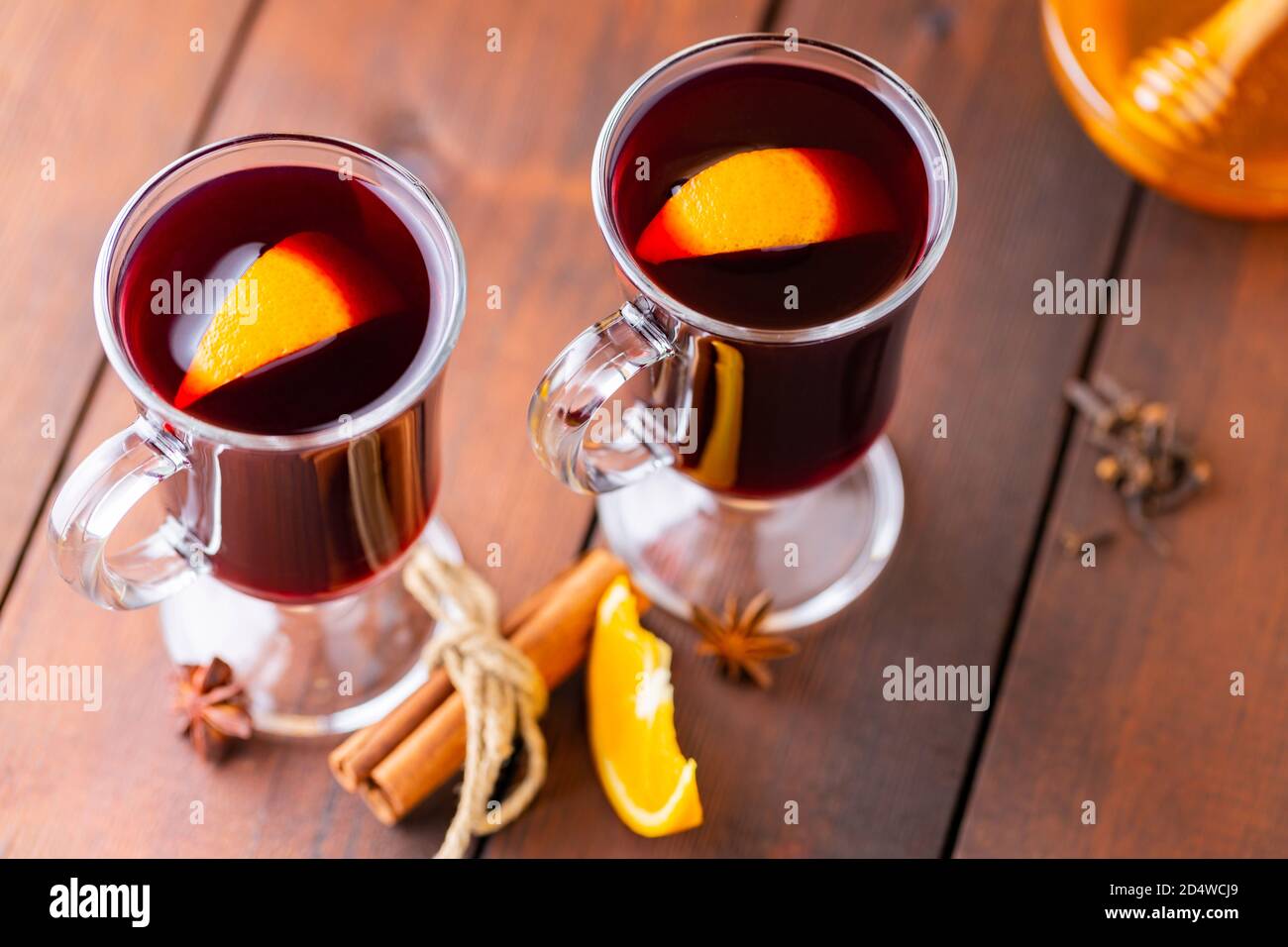 Glühwein auf Holzbrettern. Herbstlicher Glühwein, Gewürze und Honig. Weihnachts-Heißgetränk im rustikalen Stil Stockfoto