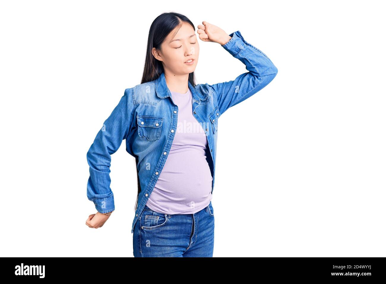 Junge schöne chinesische Frau schwanger erwartet Baby Stretching zurück, müde und entspannt, schläfrig und Gähnen für den frühen Morgen Stockfoto