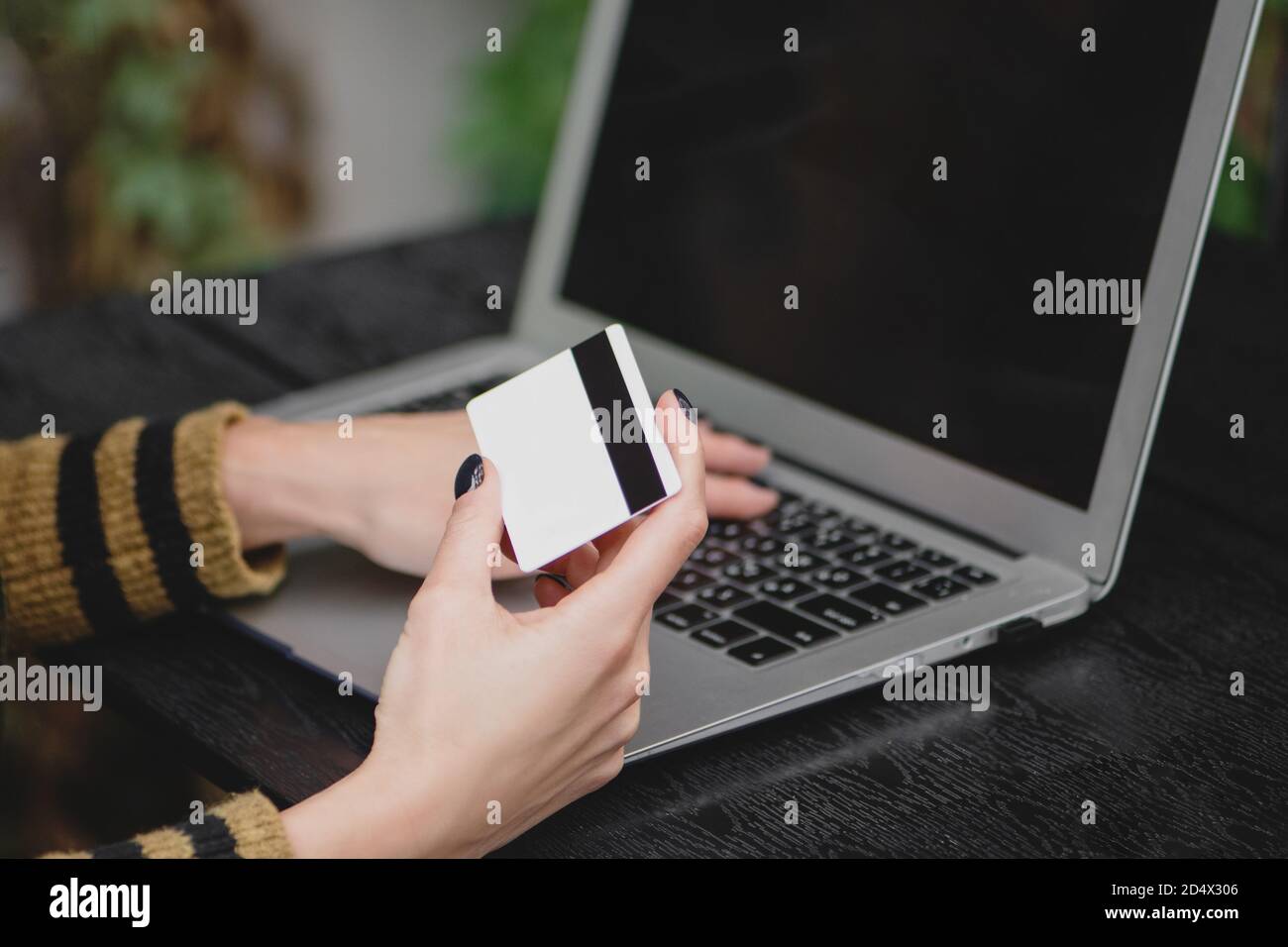 Nahaufnahme der weiblichen Hand halten Kreditkarte über Laptop für Online-Shopping. Stockfoto