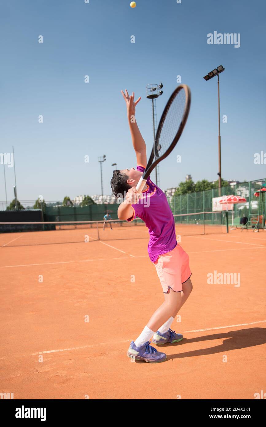 Junger Tennisspieler, der den Ball bedient Stockfoto