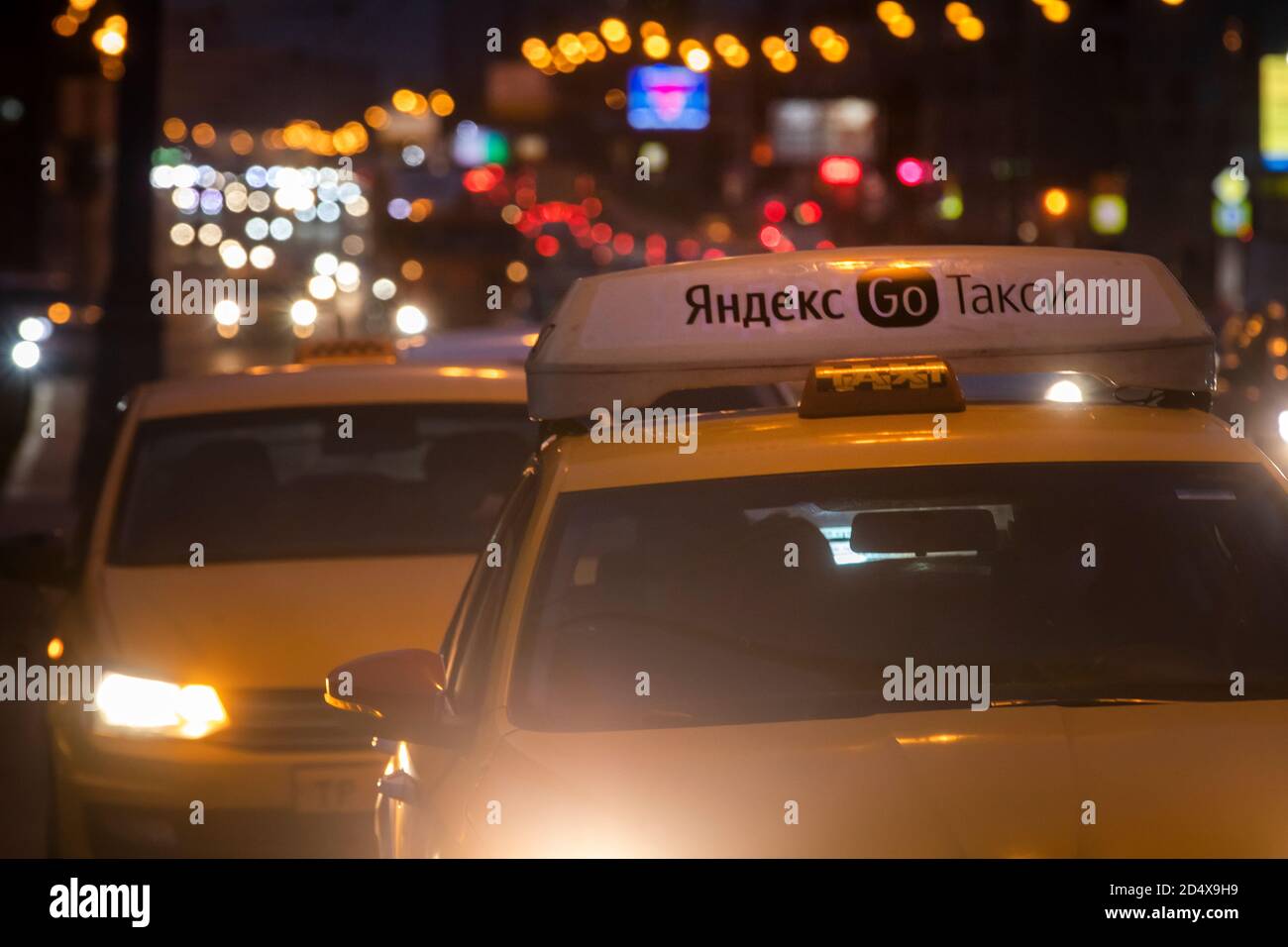 Gelbes Taxi mit Banner "Yandex Taxi" auf Türen eines Autos wartet auf den Passagier in der Nacht Straße im Zentrum von Moskau, Russland Stockfoto