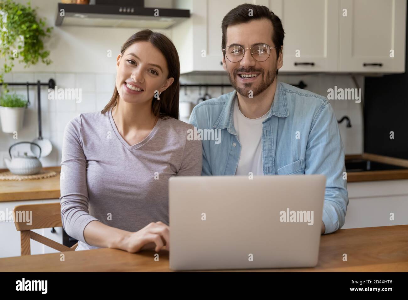 Porträt der glücklichen Familie sitzen am Küchentisch mit Laptop. Stockfoto