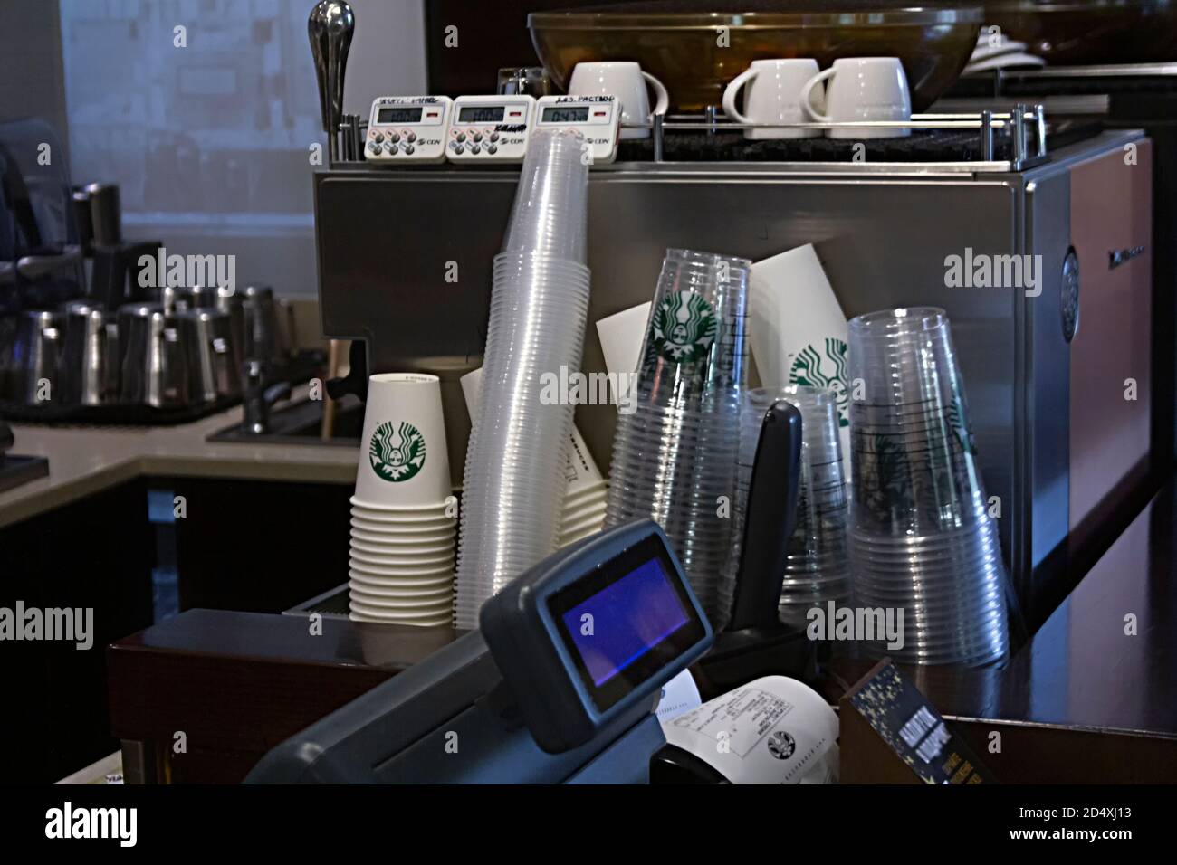 Saint-Petersburg, Russland - 03. OKTOBER 2020 Starbucks Einweg-Pappbecher stehen in der Nähe einer Kaffeemaschine und Kasse in einem Starbucks Café Stockfoto