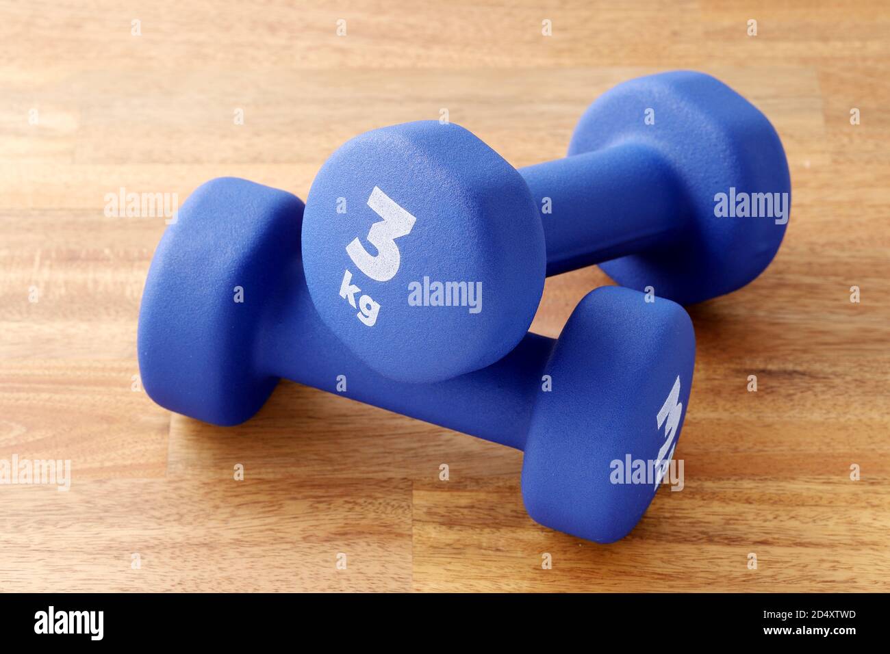 Zwei Paar blaue Fitness-Hanteln auf Holzboden, Konzept gesunde Lebensweise, Sport und Ernährung. Sportausrüstung. Stockfoto