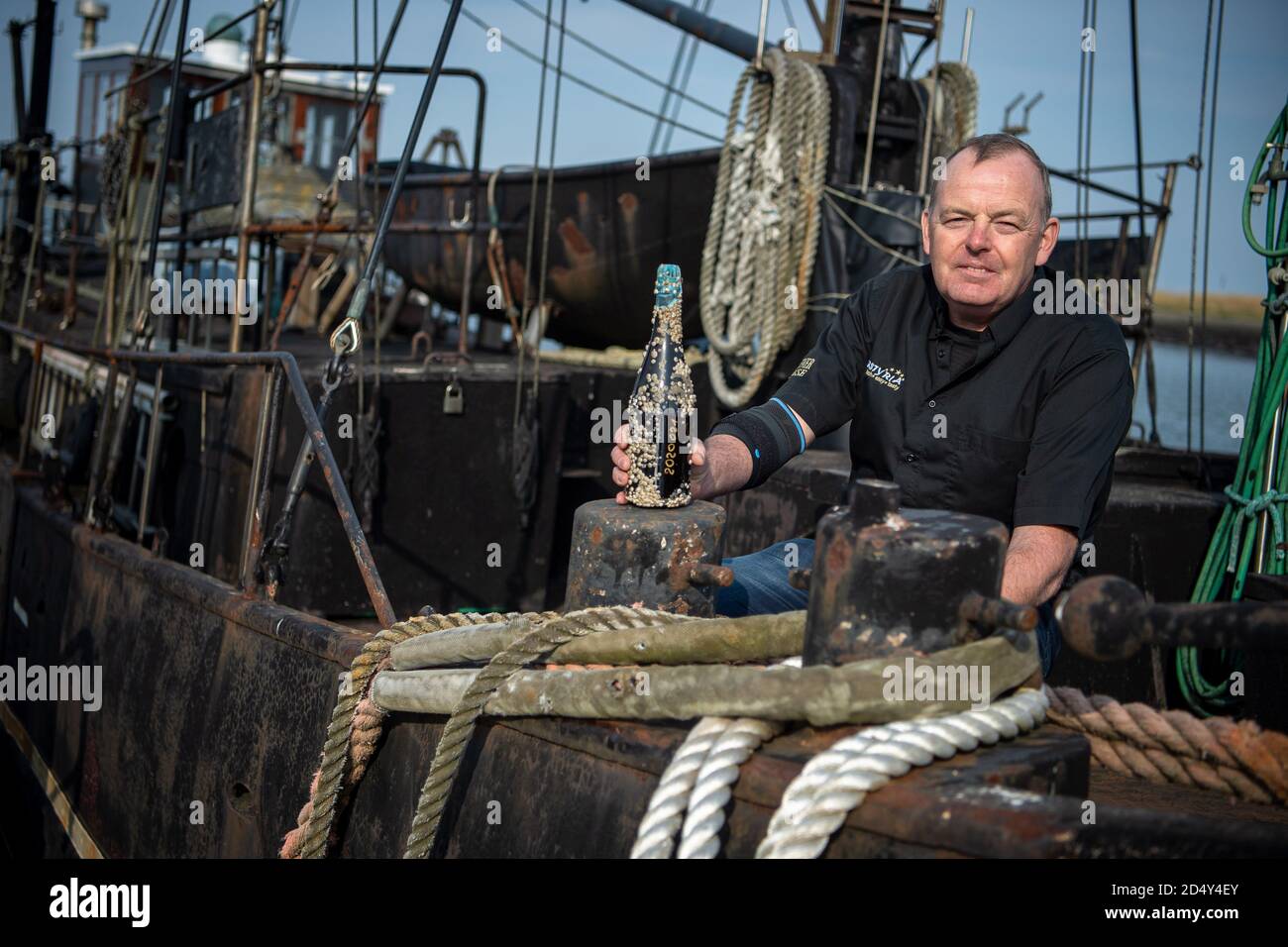 Cuxhaven, Deutschland. Oktober 2020. Oliver Köhn steht auf einem Schiff mit einer Flasche Seeposenbier. (To dpa 'Cuxhavener brauen Seepockenbier') Quelle: Sina Schuldt/dpa/Alamy Live News Stockfoto