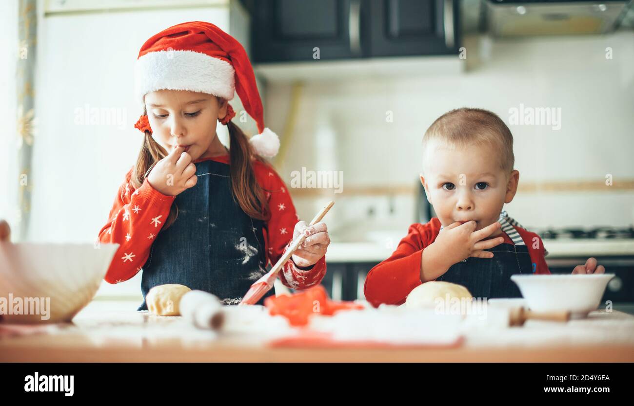 Kaukasische Bruder und Schwester, die Nahrung für die weihnachtsfeiertage vorbereiten Tragen weihnachtsmann Kleidung in der Küche Stockfoto