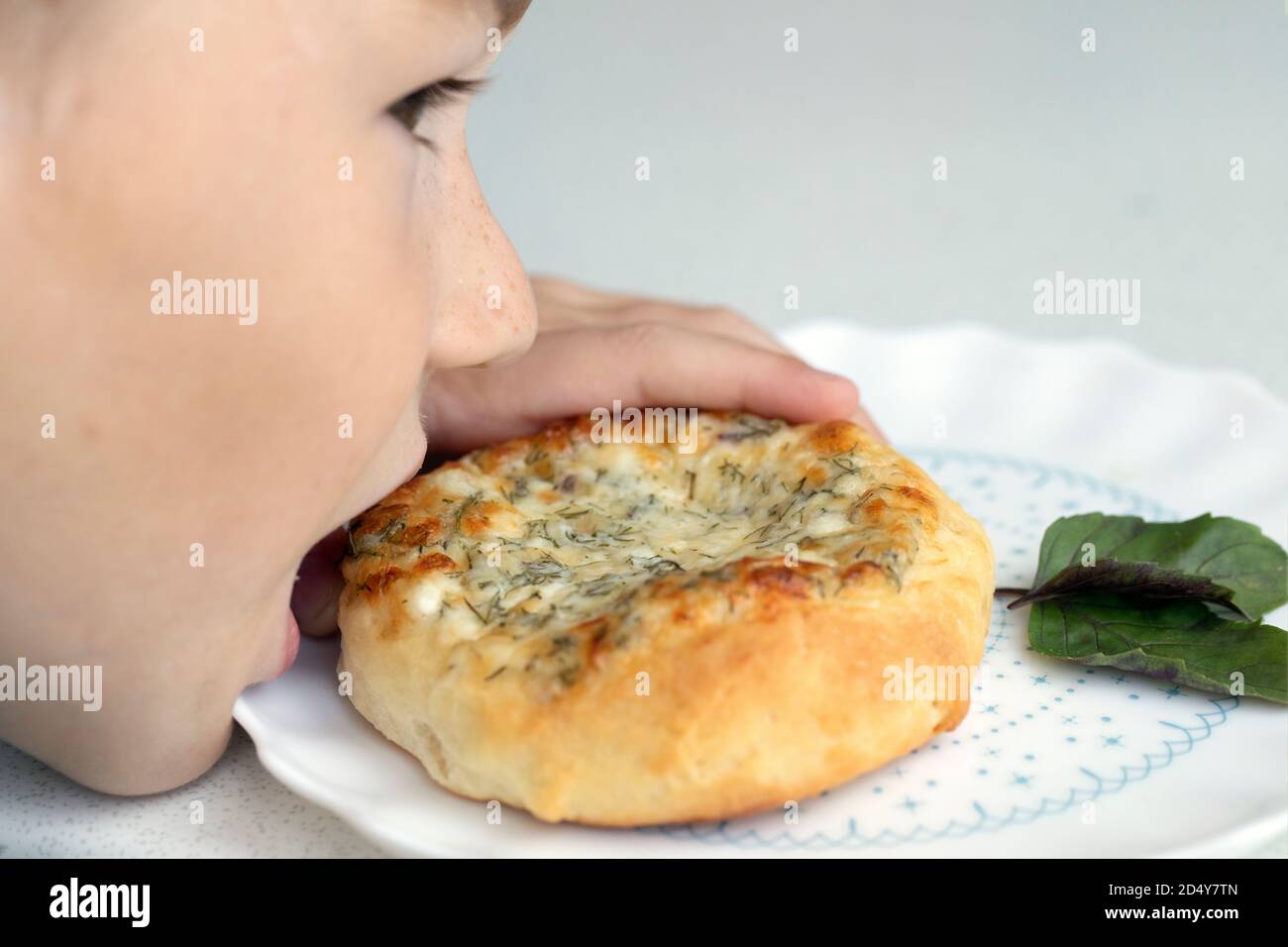Kleiner Junge essen heimlich Käse runden Brötchen. Leckeres Essen für Kinder. Stockfoto