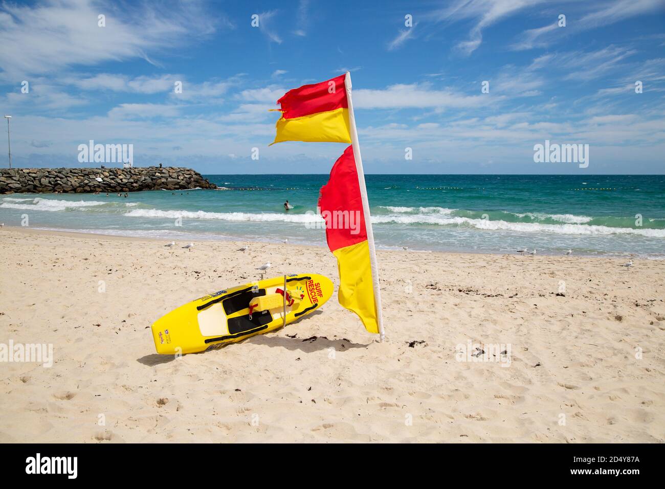Perth, Australien - 7. Oktober 2020: Surf Rettungsschwimmer Flagge und Board am Strand von Cottesloe mit dem Meer im Hintergrund Stockfoto