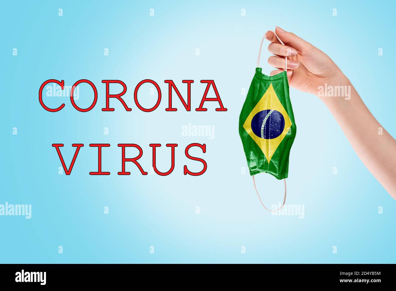 Virenschutz. Die Hand einer Frau hält eine medizinische Maske mit einer Flagge Brasilien. Blauer Hintergrund. Konzept einer Coronavirus-Pandemie und Schutz. Stockfoto
