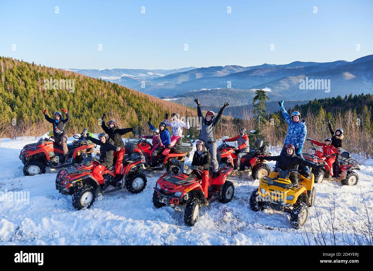 Yaremche, Ukraine - 02. Februar 2020: Gruppe von fröhlichen Menschen sitzen auf ATV-Bikes, Spaß an schönen Wintertag in verschneiten Bergen, atemberaubende Bergrücken im Hintergrund. Stockfoto