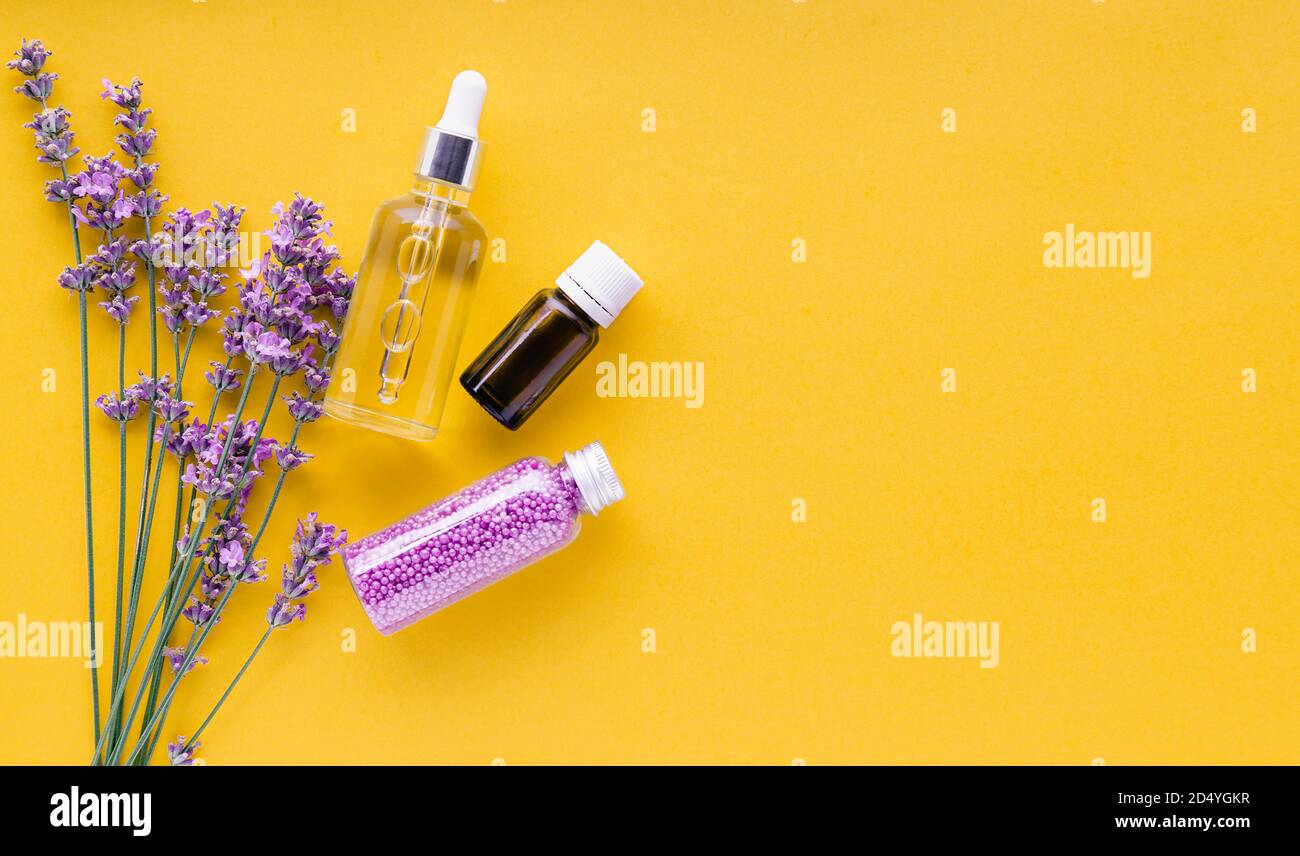 Set Lavendel Hautpflegeprodukte. Natürliche Spa Beauty-Produkte frische Lavendelblüten Kräuter auf gelbem Hintergrund. Lavendel ätherisches Öl Serum Stockfoto