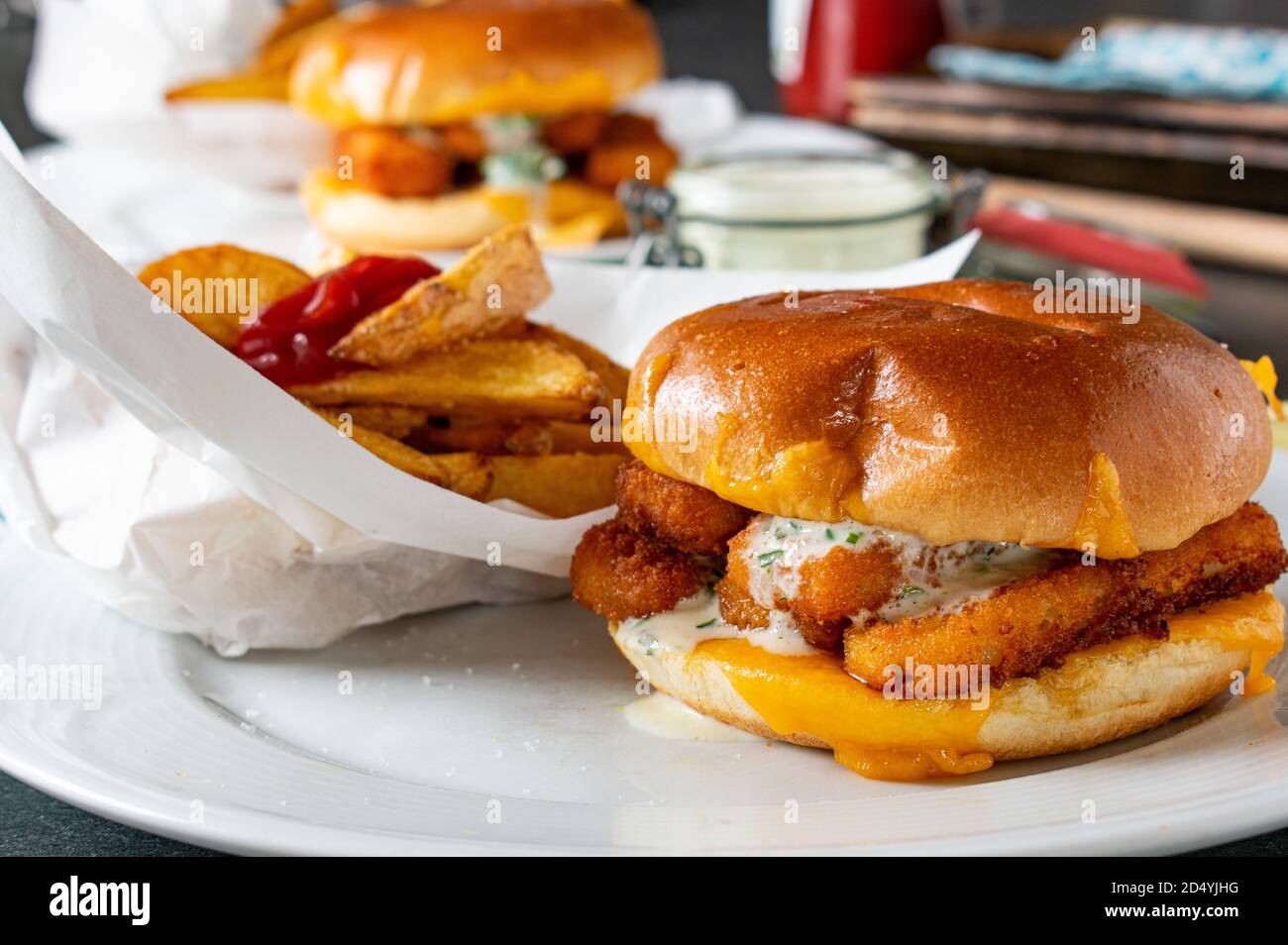 Fastfood-Mahlzeit mit Fisch Burger pommes Frites und tatar Soße Stockfoto