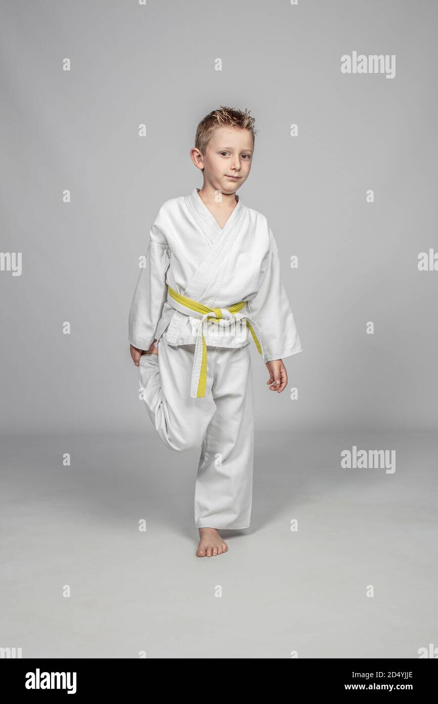 Sieben Jahre altes kaukasisches Kind, das Kampfkunst übt. Studioaufnahme. Stockfoto
