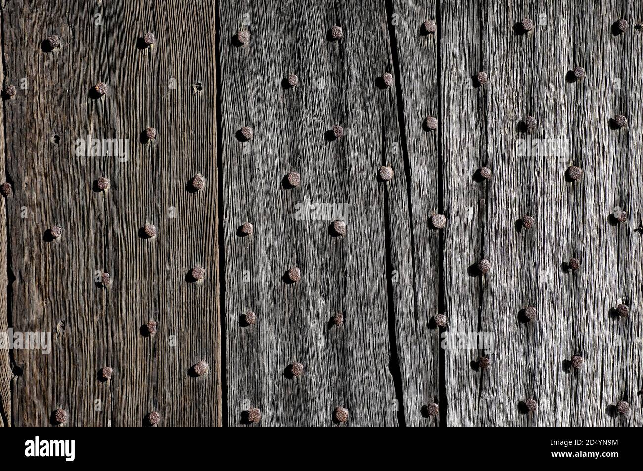 Alte mittelalterliche verwitterte Tür mit rostigen Nägeln Stockfoto