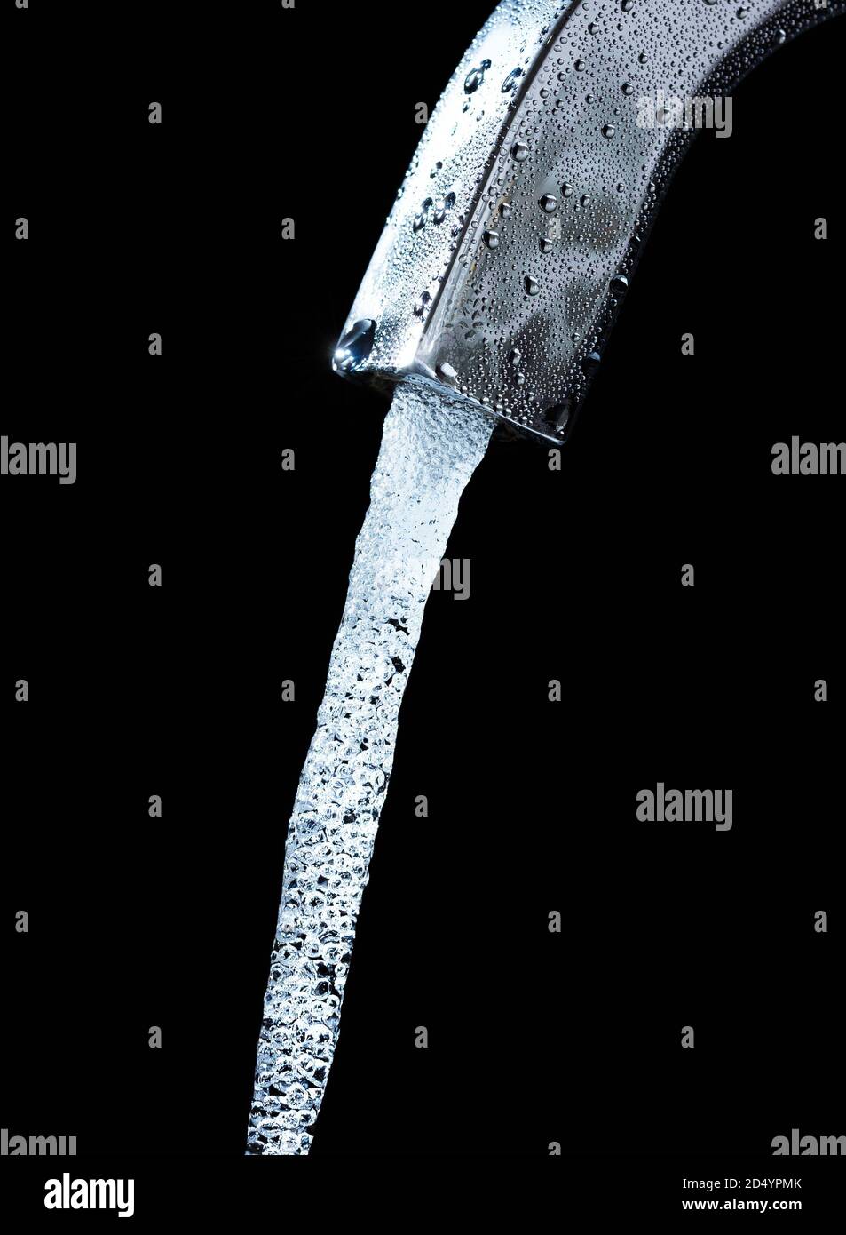 Sauberes, kaltes Wasser fließt aus einem vernebelten Wasserhahn vor schwarzem Hintergrund. Stockfoto