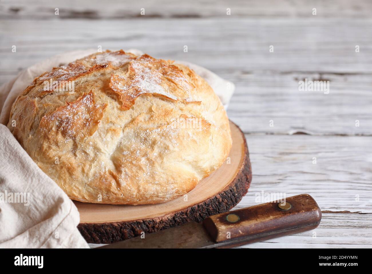 Frisches hausgemachtes hausgemachtes Brot auf einem Schneidebrett mit Geschirrtuch und Messer. Stockfoto