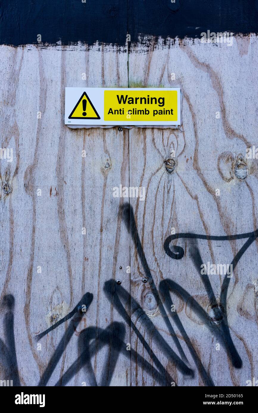 'Warnung Anti Climb Farbe' Zeichen der Graffiti bedeckt Holzzaun Stockfoto