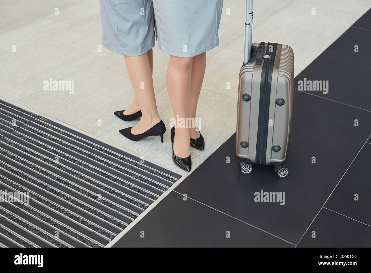 Niedriger Abschnitt Hintergrund von zwei eleganten jungen Frauen tragen Absätze stehen am Koffer im Flughafen, kopieren Raum Stockfoto