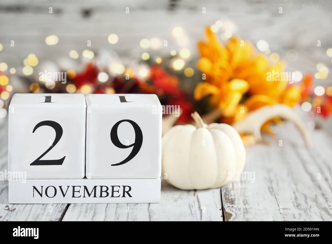 Weiße Holz Kalenderblöcke mit dem Datum 29. November und Herbst Dekorationen über einem Holztisch. Selektiver Fokus mit unscharfem Hintergrund. Stockfoto
