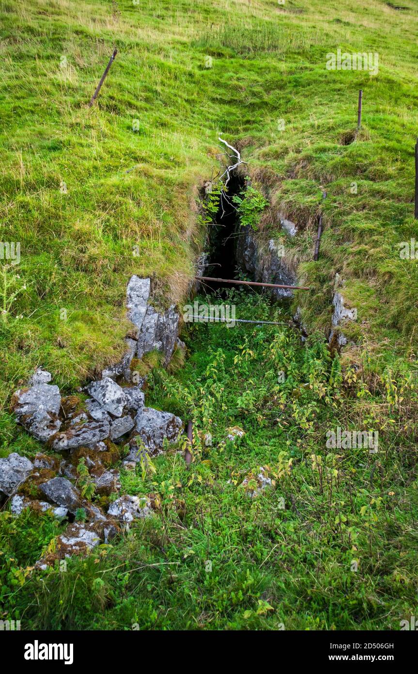 Stolleneingang zu einer alten Bleimine an der Seite eines steilen Hügels in Derbyshire. Stockfoto