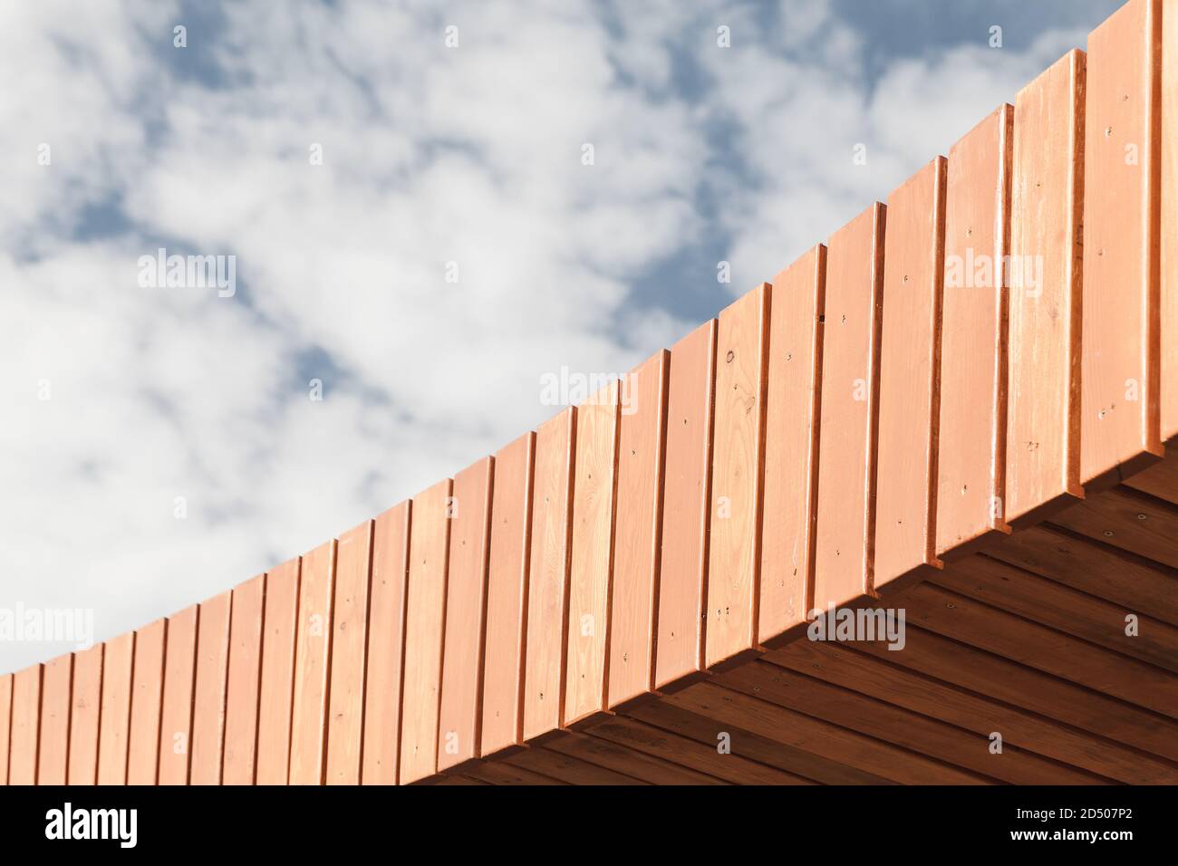 Abstrakte Holzdachkonstruktion ist unter bewölktem Himmel am Tag. Hintergrundfotostruktur Stockfoto