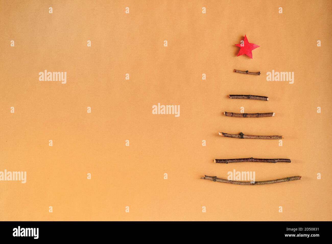 Kreativer nachhaltiger Weihnachtsbaum aus Holzstäbchen, trockenen Beeren und Tannenzapfen. Minimales DIY-Design auf Bastelpapier Hintergrund mit Kopierplatz. Kein natürliches Kunststoffdesign. Stockfoto