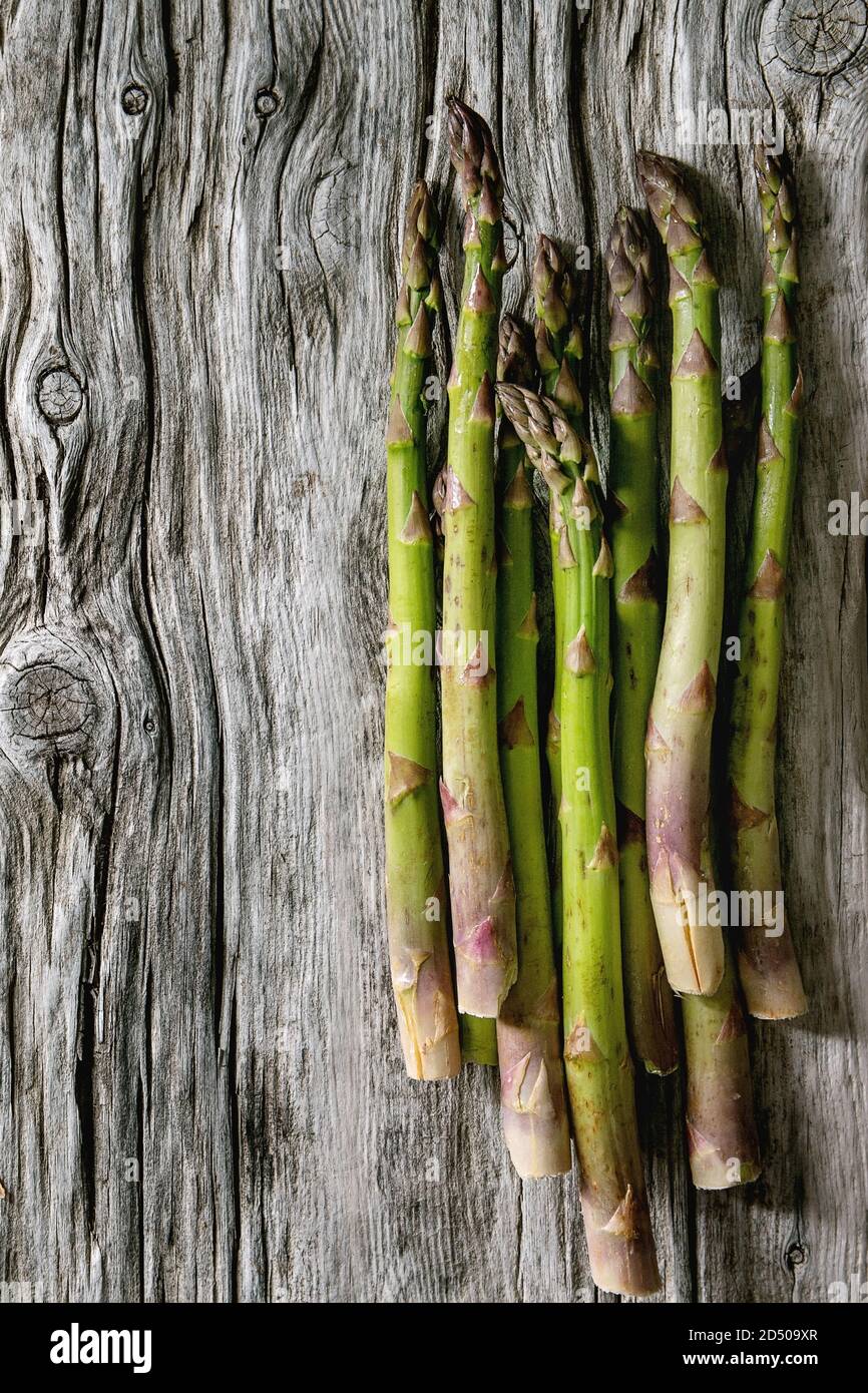 Bündel von raw Organic Green Spargel über alte Holz- Hintergrund. Flach, Raum Stockfoto