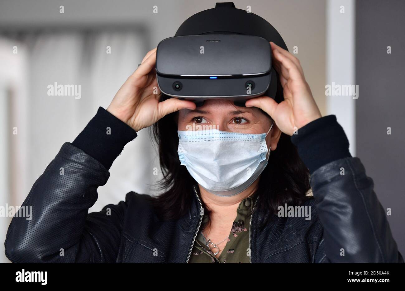 Jena, Deutschland. Oktober 2020. Anja Siegesmund (Bündnis90/die Grünen), Ministerin für Umwelt Thüringens, trägt bei der Führung durch das DLR-Schülerlabor und das Citizens Science Laboratory am Institut für Datenwissenschaften des Deutschen Zentrums für Luft- und Raumfahrt (DLR) eine VR-Brille. Sie will sich auch über Erfassungssysteme für Klimadaten informieren. Quelle: Martin Schutt/dpa-Zentralbild/dpa/Alamy Live News Stockfoto