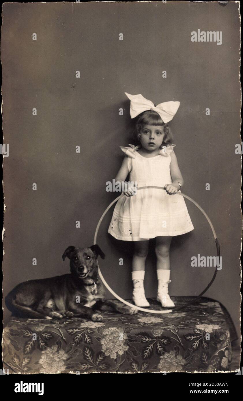 Mädchen in weißem Kleid mit Reifen und Hund Weltweit Stockfoto