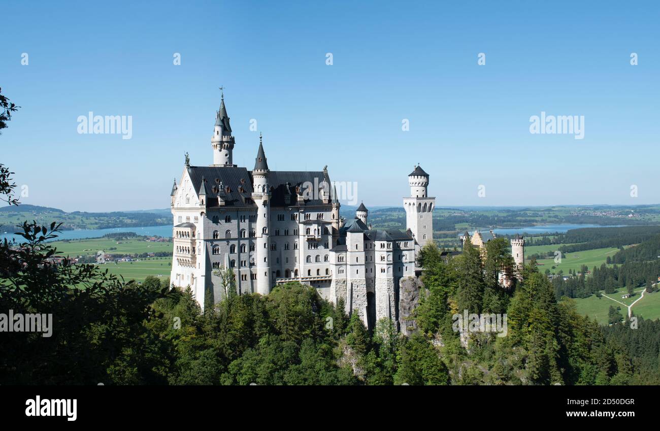 Nahaufnahme des Traumschlosses Ludwig II. Von Bayern, mit klarem Himmel und sommerlich grünen Bäumen und Wiesen im Hintergrund Stockfoto