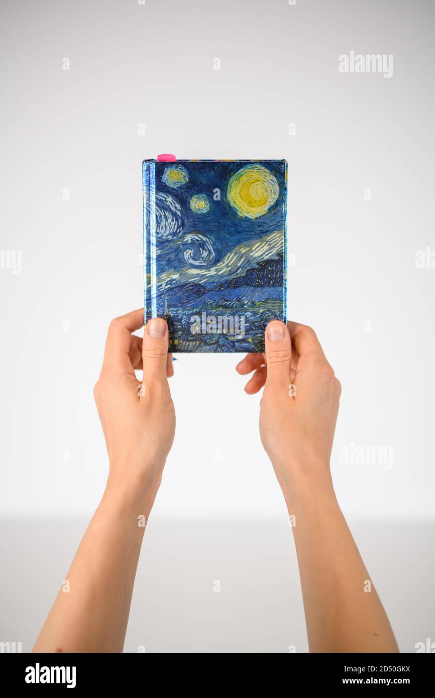 Hände halten ein Notebook hoch Stockfoto