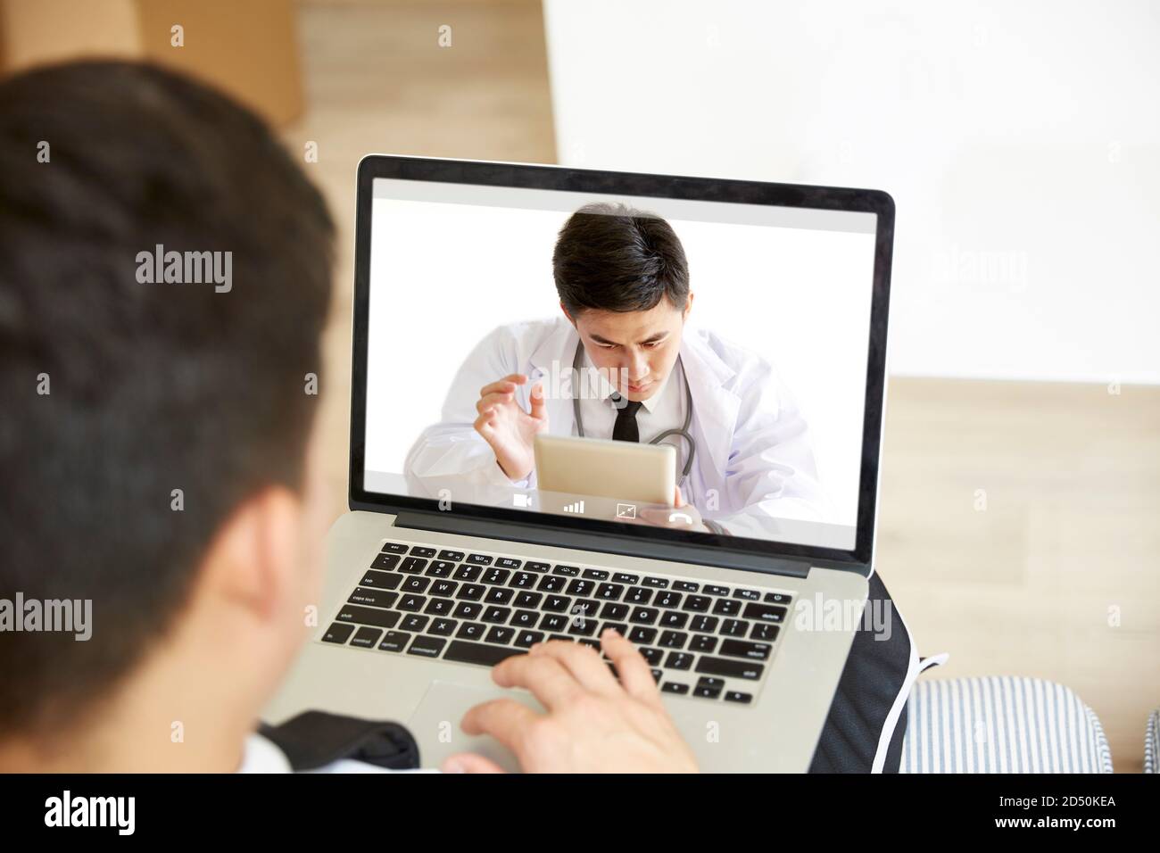 Junge asiatische Mann zu Hause zu bleiben Beratung Hausarzt Online über Video-Chat mit Laptop-Computer Stockfoto