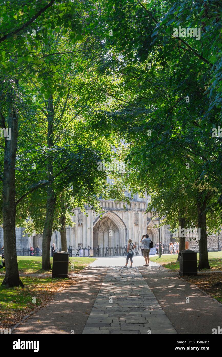 England Sommerstadt, Blick im Sommer auf die Menschen stehen in der Kathedrale Gelände in der Hampshire Stadt Winchester, England, Großbritannien. Stockfoto