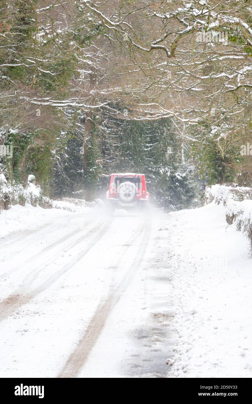 Rotes 4x4-Auto auf einer verschneiten Winterstraße, in der Nähe von Consett, County Durham, Großbritannien Stockfoto